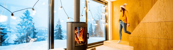 Frau vor Kamin und großem Fenster